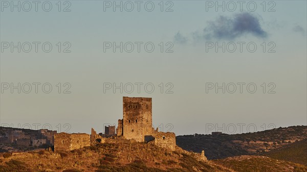 An old castle ruin under a sky with sunset, reflecting the silence of the surroundings, a