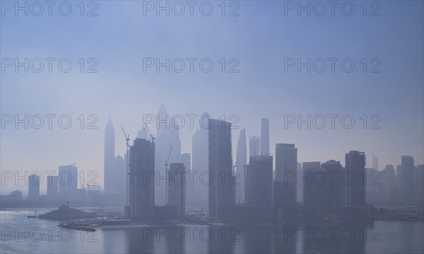 Morning fog, skyline with Princess Tower, Elite Residence, luxury yacht OPERA owned by Sheikh