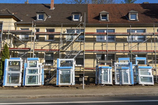 Energy-efficient refurbishment of residential buildings, older apartment block is scaffolded, gets