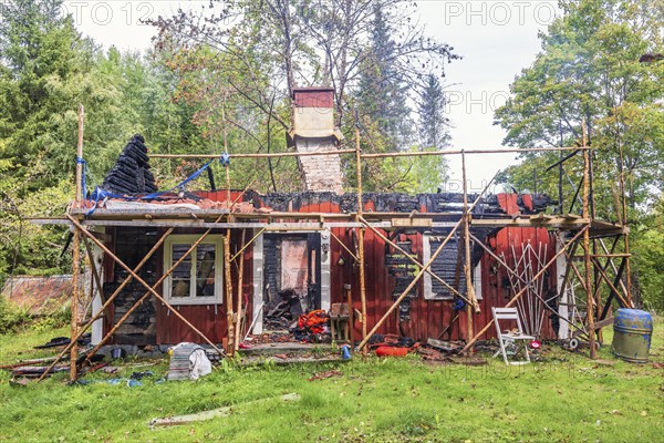 Red idyllic old wooden cottage that has burned down in the forest, Sweden, Europe