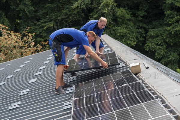 Installation of solar modules on the roof of a barn on a farm, over 240 photovoltaic modules are
