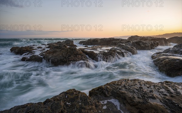Waves washing over rocks by the sea, long exposure, coastal landscape at sunset, Playa Cocalito,