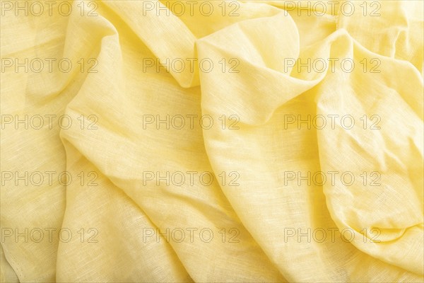Fragment of yellow linen tissue. Top view, flat lay, natural textile background and texture. wave