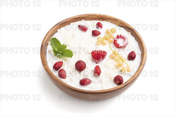 Rice flakes porridge with milk and strawberry in wooden bowl isolated on white background. Side