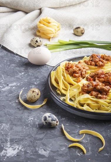 Tagliatelle bolognese pasta with minced meat on a black concrete background. side view, close up