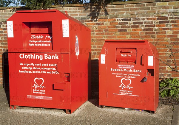 Red British Heart Foundation charity collecting containers for clothing, books and music, UK