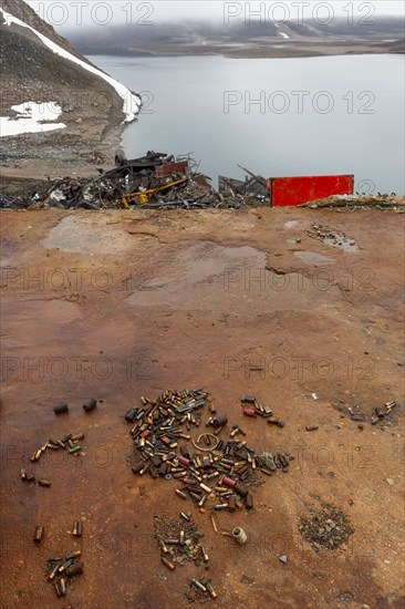 Rusted bullet casings, leaking rusty batteries and scrap metal, arctic settlement Ittoqqortoormiit,