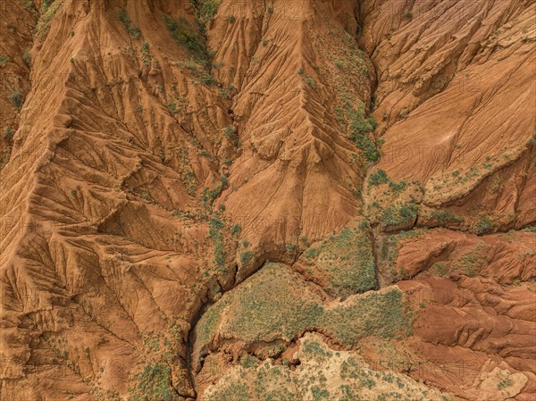 Eroded mountain landscape, top-down, canyon with red and orange rock formations, aerial view,