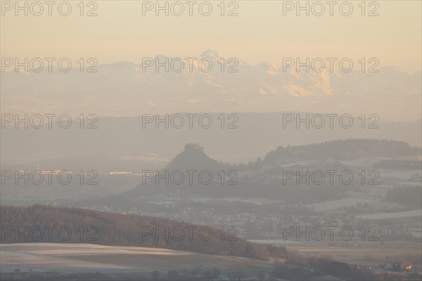 Hegaublick in winter and sunset. Hohenkrähen castle ruins with the Alps and the Säntis