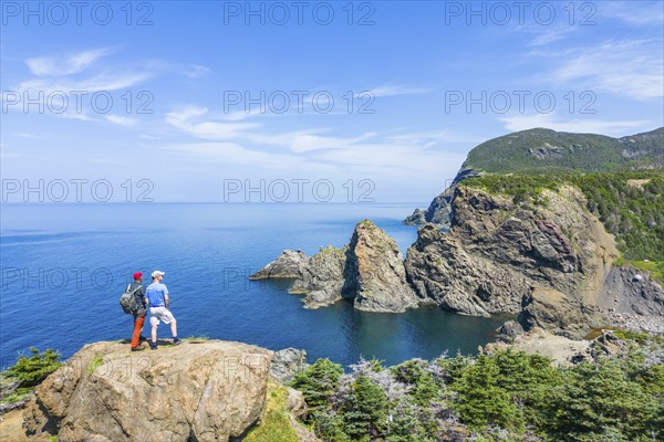 Aerial view, drone photo: Two men standing on a cliff above Bottle Cove, Bottle Cove Provincial