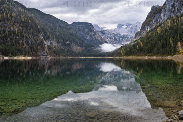 The Vordere Gosausee lake in autumn with a view of the Dachstein mountain range. The Gosaukamm on