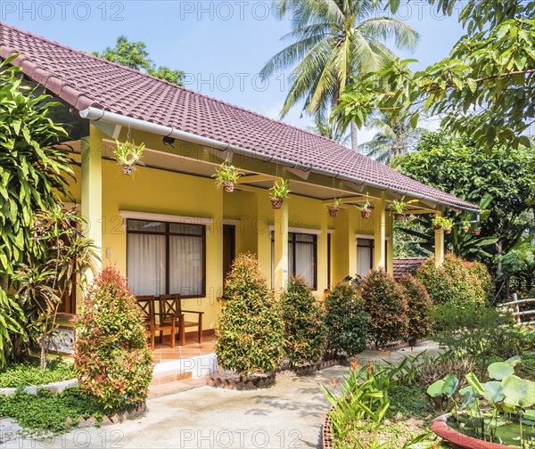Small yellow hotel building in tropical resort