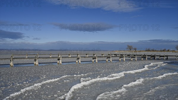Frozen lake with ice and footbridge in winter, Lake Neusiedl, Podersdorf am See, Burgenland,