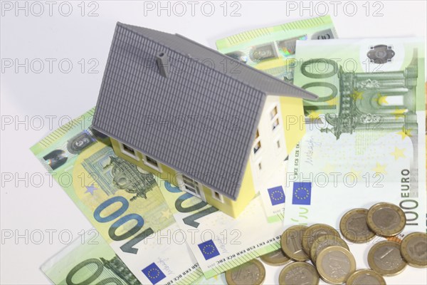 Symbolic image for property prices: Model house, euro notes and coins