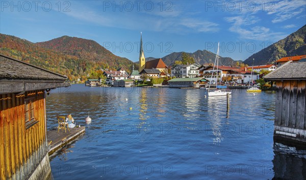 Boathouses at Malerwinkelblick with waterfront of the village, St. Laurentius parish church in