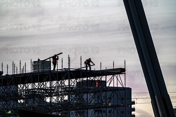 Workers dismantle scaffolding on the Erasmus Bridge over the Nieuwe Maas in Rotterdam, Netherlands