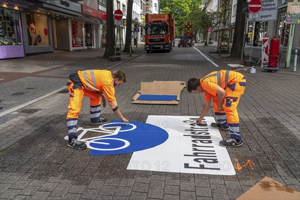 Application of road markings for a cycle lane, Rüttenscheider Straße in Essen, in the shopping and