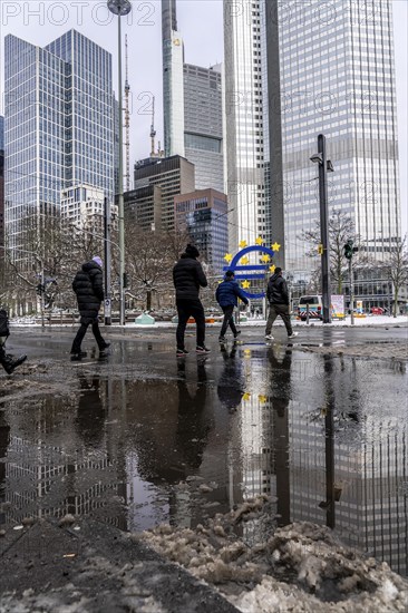 Winter in the city, Gallusanlage street, puddles, pools of water, melt water, pedestrians,