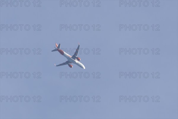 Airbus A320 aircraft of Easyjet airlines in flight across a blue sky, England, United Kingdom,