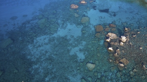 Drone shot, Clear view of the rocky seabed through azure waters revealing a tranquil underwater