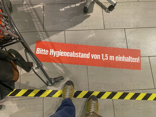 Effects of the corona crisis in Germany, sticker on the floor informs customers of a supermarket