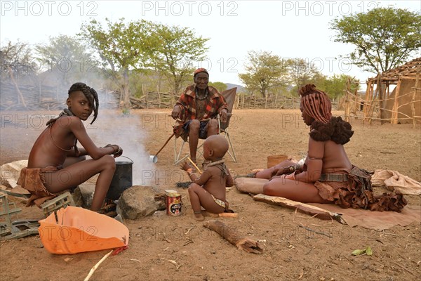Chief Hikuminue Kapika, tribal leader of the Namibian Himba people, sitting with his family at a