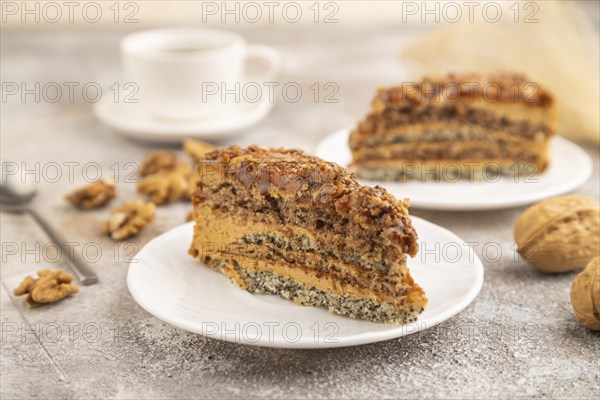 Walnut and hazelnut cake with caramel cream, cup of coffee on brown concrete background. side view,