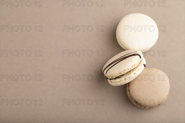 Brown and white macaroons on beige pastel background. top view, flat lay, copy space, still life.