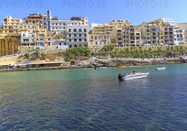 Waterfront hotel buildings beach and sea at Xlendi, island of Gozo, Malta, Europe