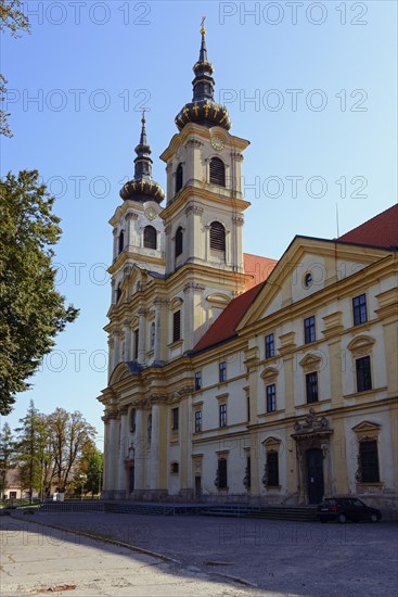 Baroque church with two towers and golden decorations under a clear blue sky, Basilica of St Mary