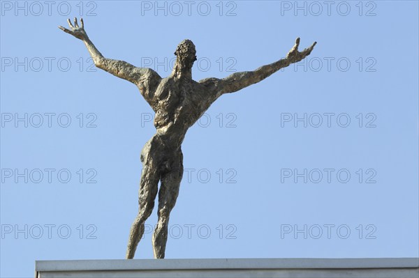 Sculpture The Flight by Rainer Retting 1997, roof, flying, figure, man, arms, outstretch, up, hold,