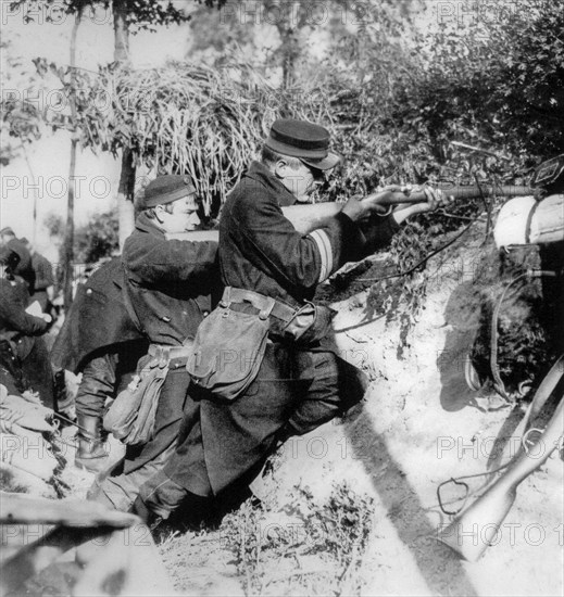 WWI Belgian infantrymen in trench shooting with Mauser Model 1889 bolt-action rifle used during