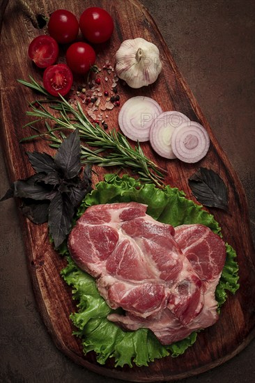 Raw pork steak, two pieces, on a wooden background