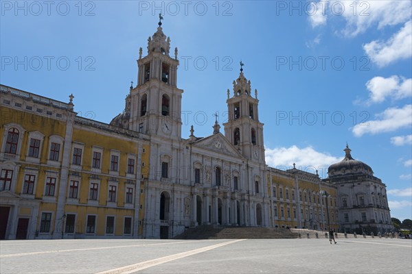 Monumental baroque architecture with two towers and detailed façade under a clear sky, National
