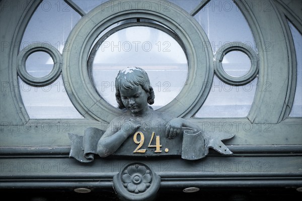 Detail of a historic door with bust of a girl and house number 24, Borups Højskole, school