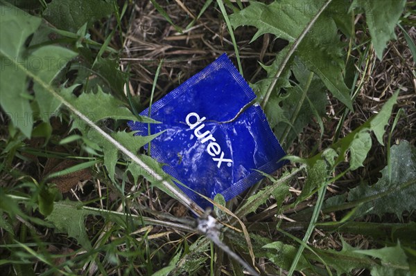 Open condom sachet dumped in nature, France, Europe