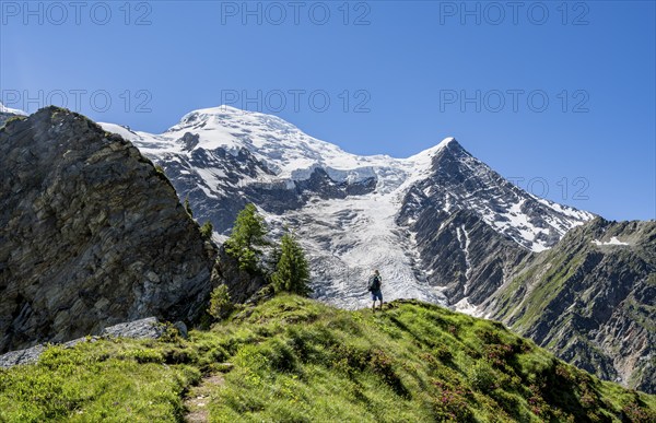 Mountaineer on a hiking trail in front of mountain landscape with glacier, view of glacier Glacier
