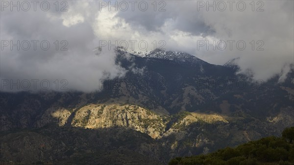 Mountain landscape with clouds and partly sunny rocks casting shadows, Lefka Ori, White Mountains,