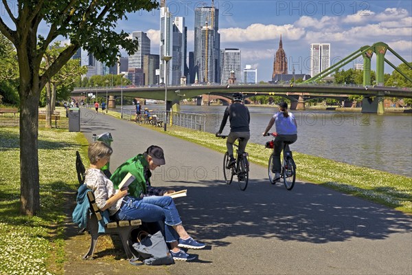 People seeking relaxation in fine weather on the Main promenade in front of the Flößerbrücke,