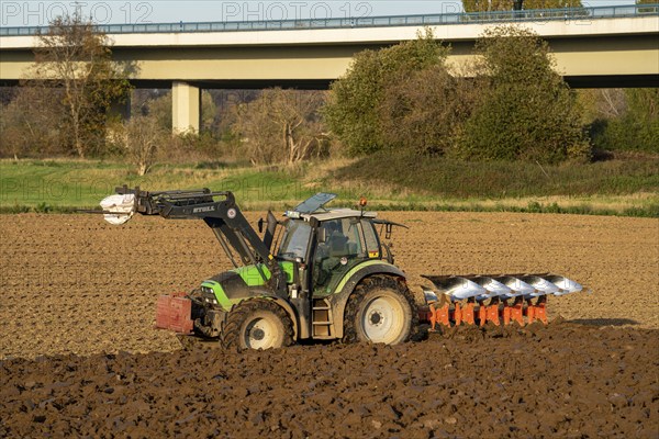 Farmer ploughing a field, tractor with plough, near Neuss, North Rhine-Westphalia, Germany, Europe