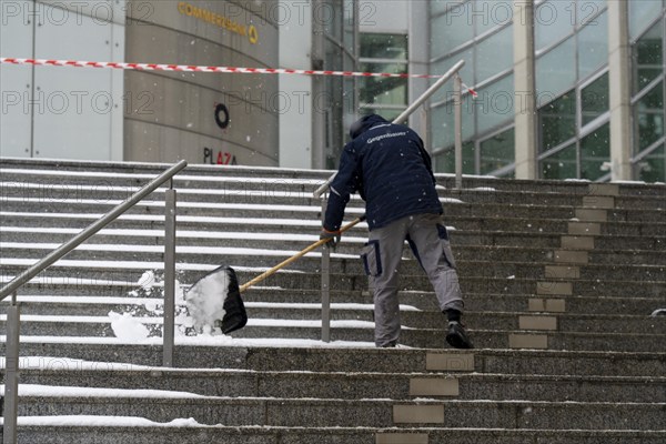 Onset of winter, winter service, clearing snow on the stairs of the Commerzbank building,