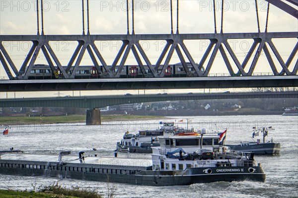 The Rhine near Düsseldorf, cargo ships, Hammer railway bridge, local train, North Rhine-Westphalia,