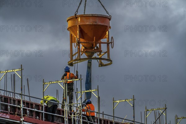 Concrete work, at dusk, on a large construction site building a residential and commercial complex,