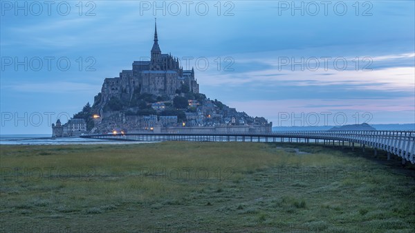 Mont Saint Michel in front of sunrise, rocky monastery island in the Wadden Sea, Le Mont Saint