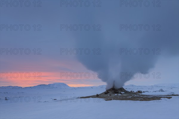 Hot springs and geothermal area in front of a mountain landscape in winter, cloudy mood, Hverir,