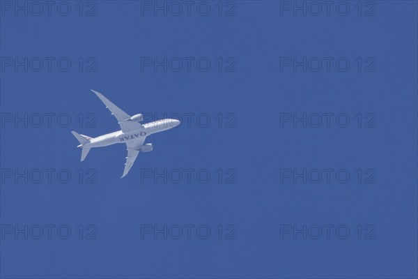 Boeing 787-8 Dreamliner jet aircraft of Qatar airlines flying in a blue sky, England, United