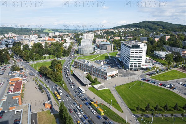 View of an urban neighbourhood with busy traffic, large green areas and surrounding mountain