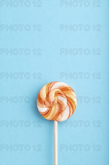 Single lollipop candy on blue pastel background. copy space, top view, flat lay
