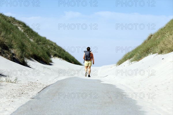 A woman walks to the beach on the island of Amrum, Norddorf, 15.06.2020