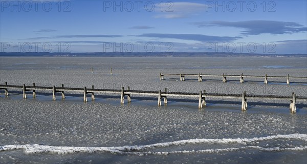 Frozen lake with ice and footbridge in winter, Lake Neusiedl, Podersdorf am See, Burgenland,